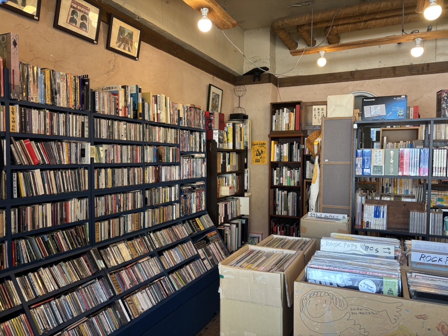 店内南側の壁一面に設置された身の丈を超す商品棚には数多くのCDが販売されている。
